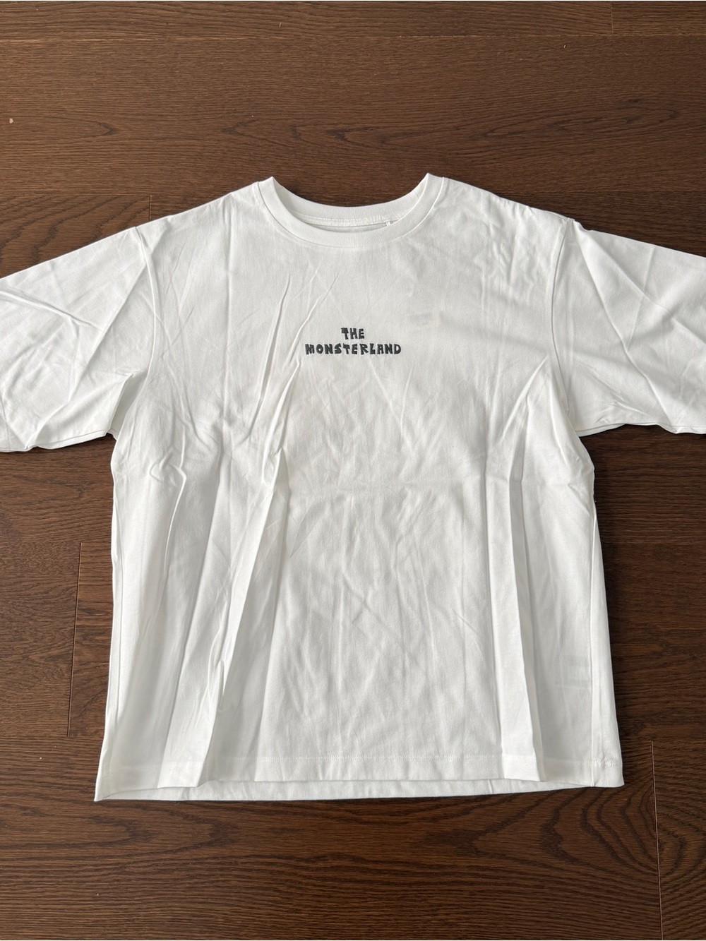 Uniqlo White Short Sleeve Tee with 'The Monsterland' Chest Print